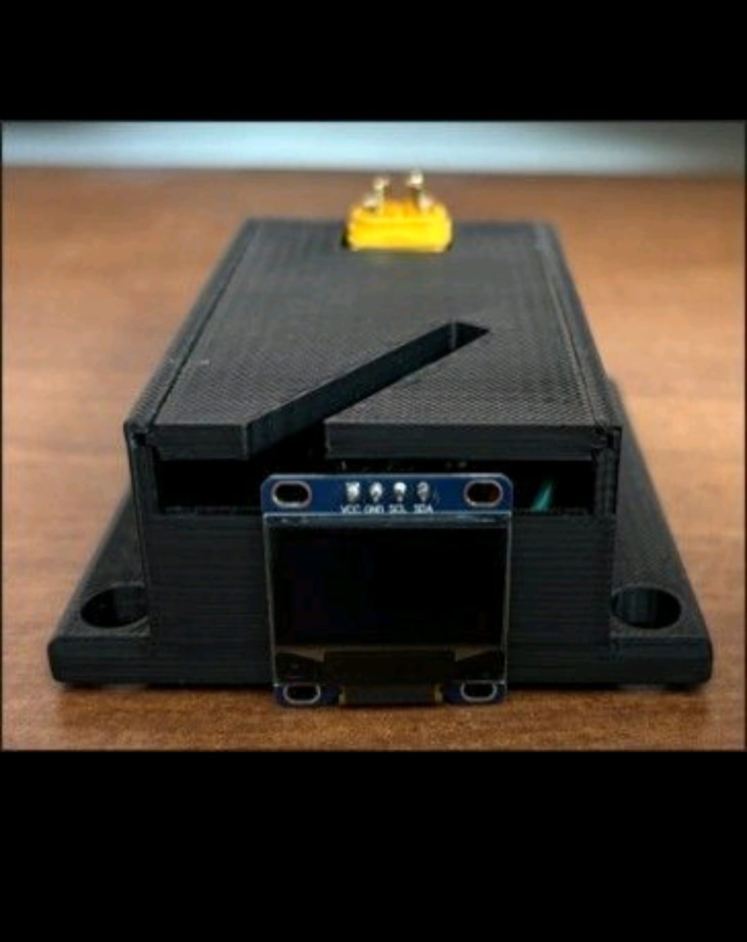 The assembled Firefighter Exoskeleton Battery Level Indicator unit, enclosure closed, with the OLED display visible on top.